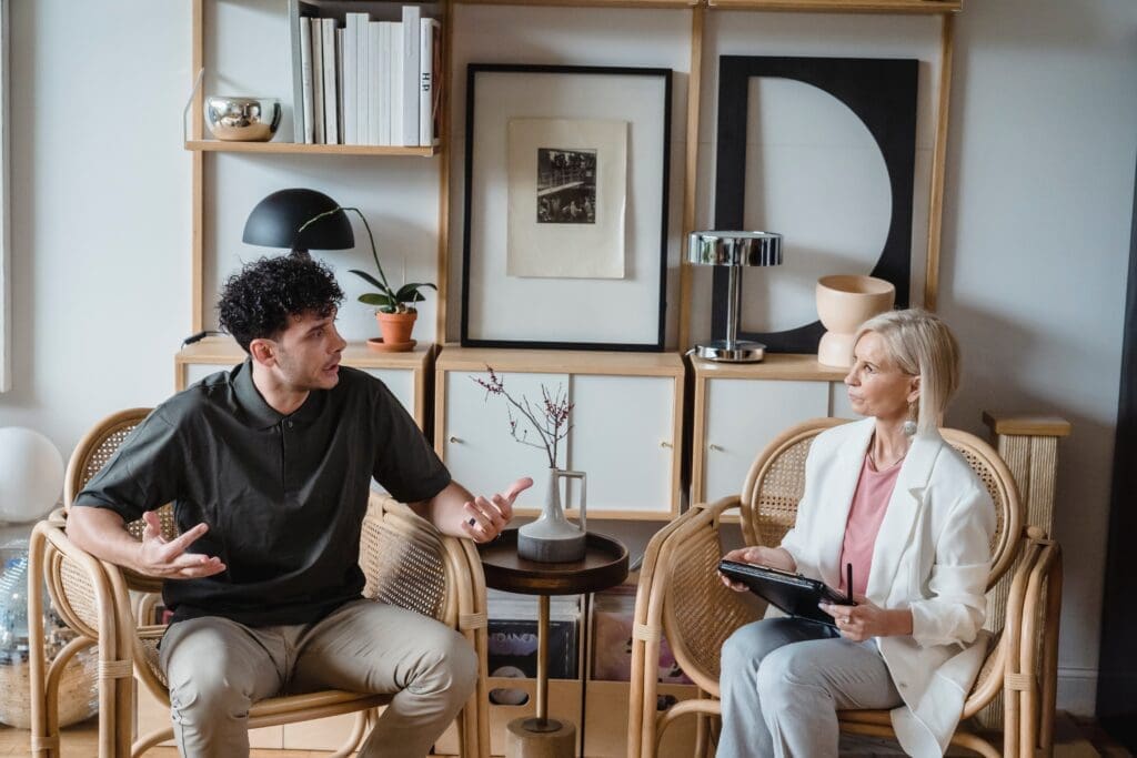 A man speaks to a female therapist during a counseling session