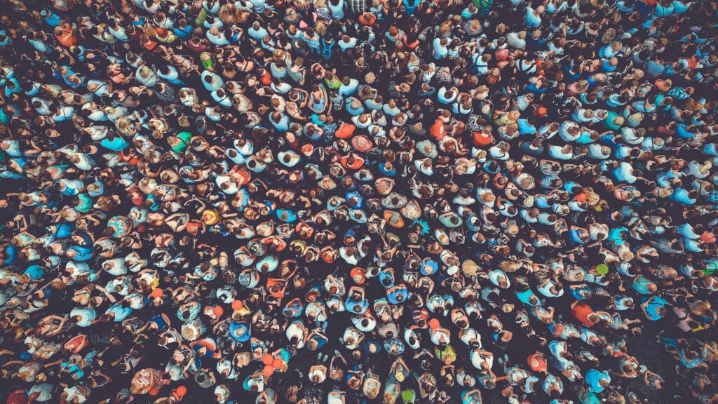 A massive crowd of humans stand shoulder to shoulder