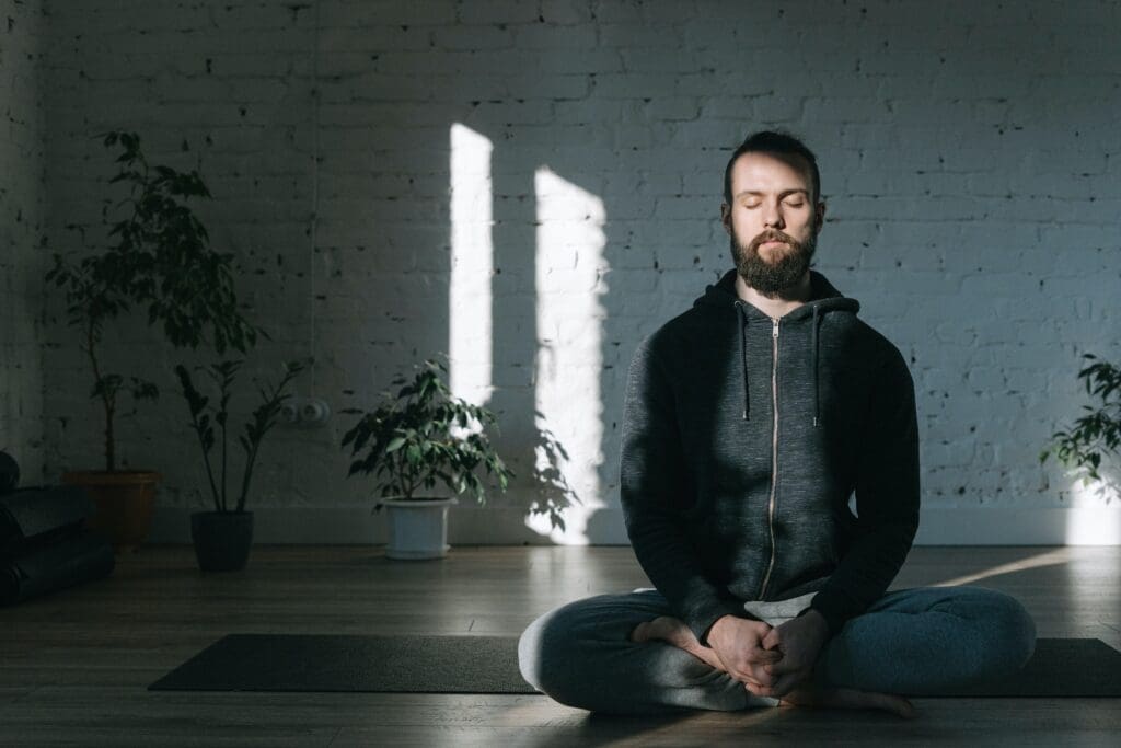A man meditates alone. A key point on how to overcome a mid-life crisis is to control your narrative