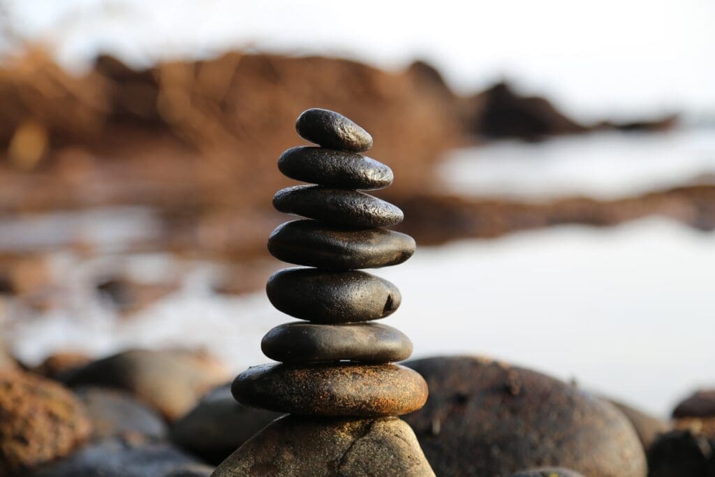 A stack of rocks sit perfectly balanced. Constructive nihilism is the perfect balance to happiness